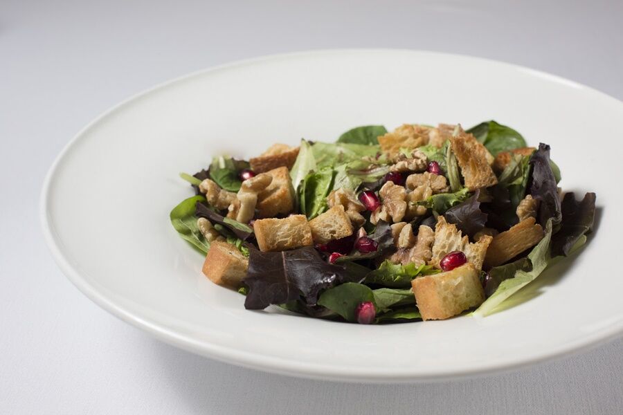 Eurostars Torre Sevilla Exterior foto The photo features a salad presented in a white bowl. The salad includes a mix of leafy greens, possibly lettuce and spinach, along with croutons and small pieces of shredded chicken. It appears to be garnished with pomegranate seeds, adding a pop of